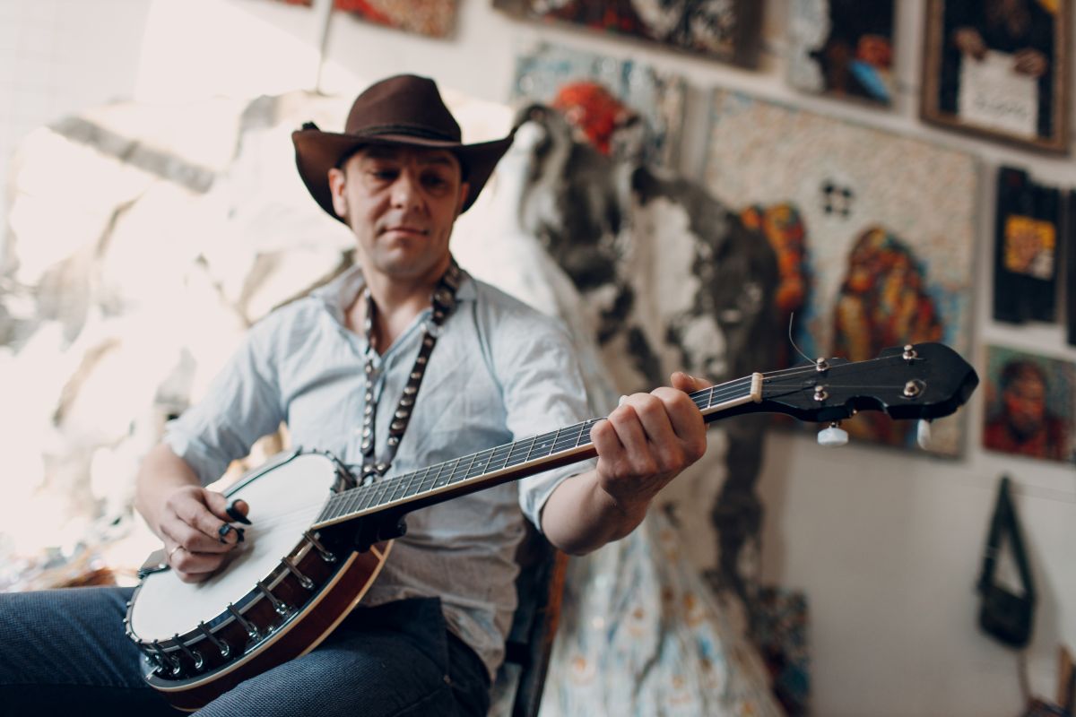 Man with a cowboy hat playing the Banjo